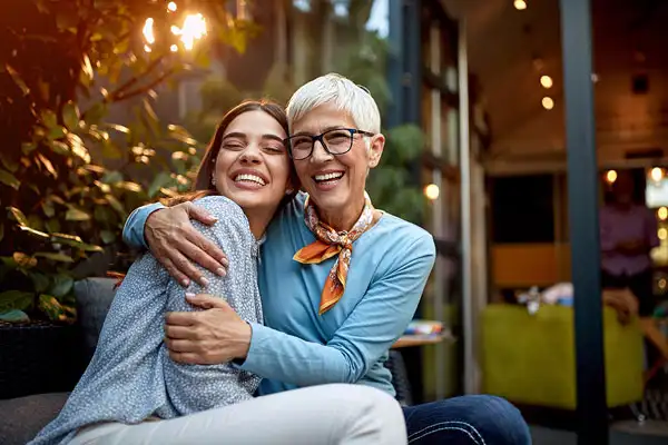 a senior mother and adult daughter, hugging, smiling. Love, affection, happiness concept