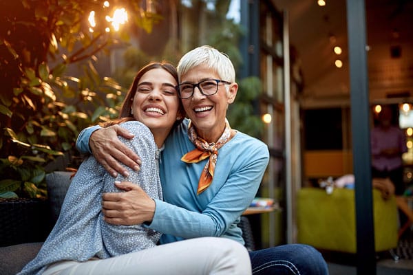 a senior mother and adult daughter, hugging, smiling. Love, affection, happiness concept