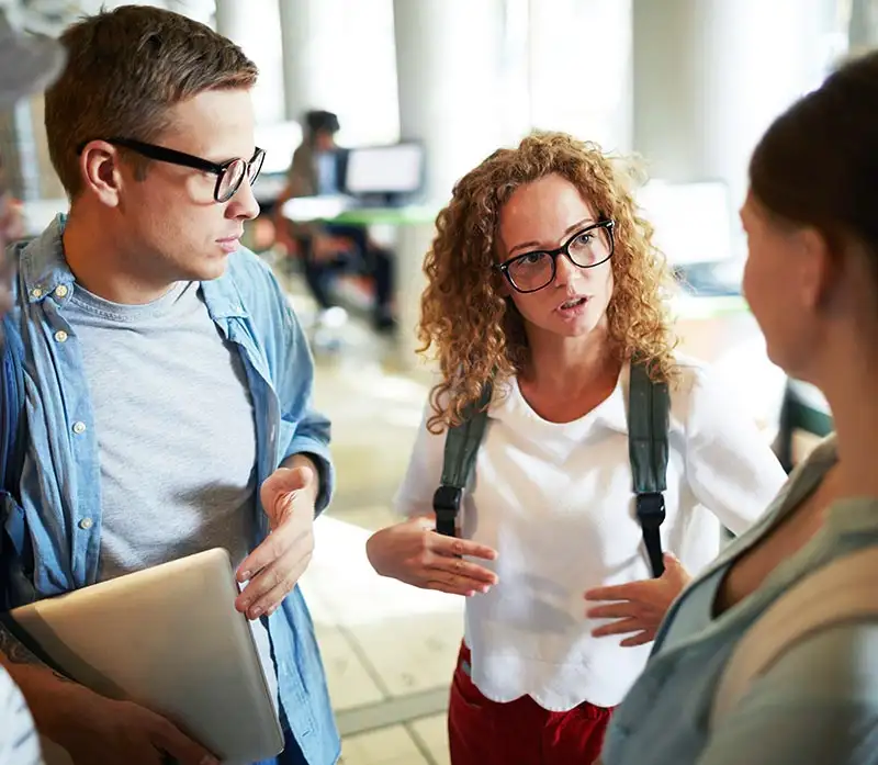 Three people conversing in a hallway, focusing on topics related to social anxiety disorder treatment